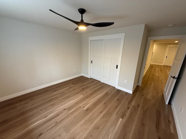 365 13th Dr, Nekoosa, WI 54457 - unfurnished bedroom featuring wood finished floors, baseboards, a closet, and ceiling fan