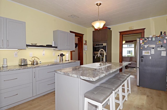 301 Van Buren St, Sauk City, WI 53583 - kitchen featuring ornamental molding, light wood finished floors, visible vents, a sink, and appliances with stainless steel finishes