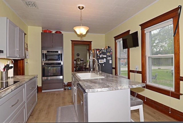 301 Van Buren St, Sauk City, WI 53583 - kitchen with light wood-style flooring, a sink, stainless steel appliances, pendant lighting, and visible vents