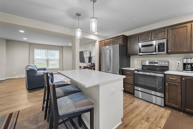5872 Tranquility Trl, Madison, WI 53718 - kitchen featuring light wood-style floors, appliances with stainless steel finishes, and dark brown cabinets