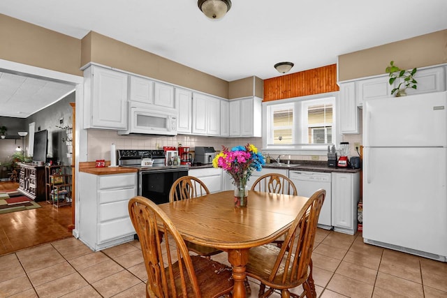 kitchen with white cabinets, white appliances, light tile patterned floors, and tasteful backsplash