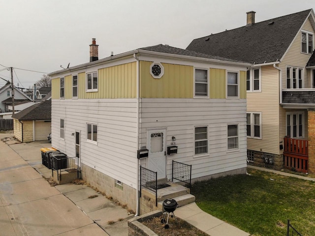 view of front of house with board and batten siding, crawl space, a chimney, and a front yard