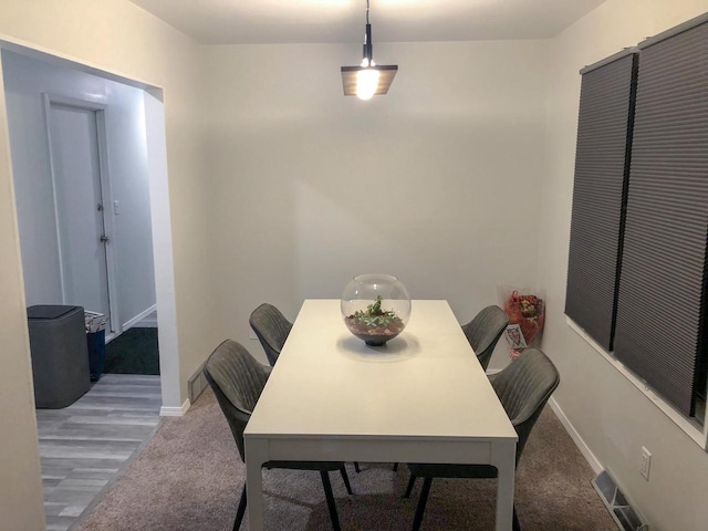 carpeted dining area with visible vents and baseboards