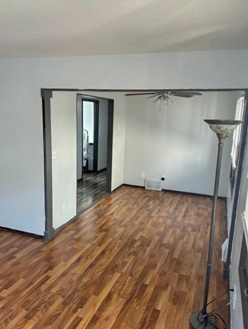 spare room with ceiling fan, wood finished floors, and visible vents