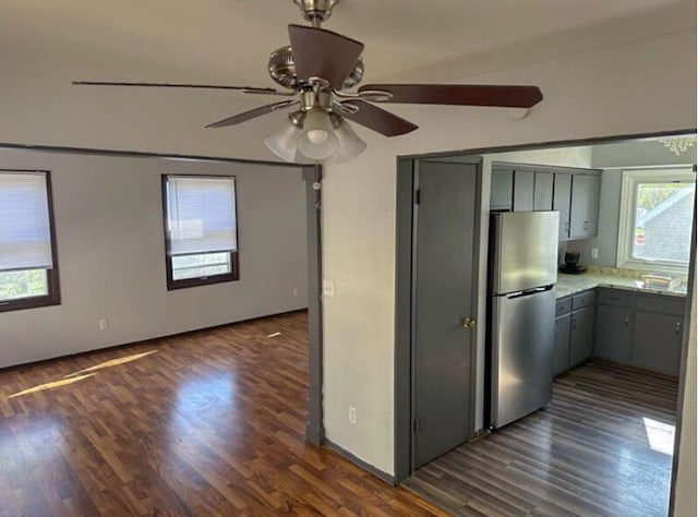 kitchen with ceiling fan, dark wood-style flooring, gray cabinetry, and freestanding refrigerator