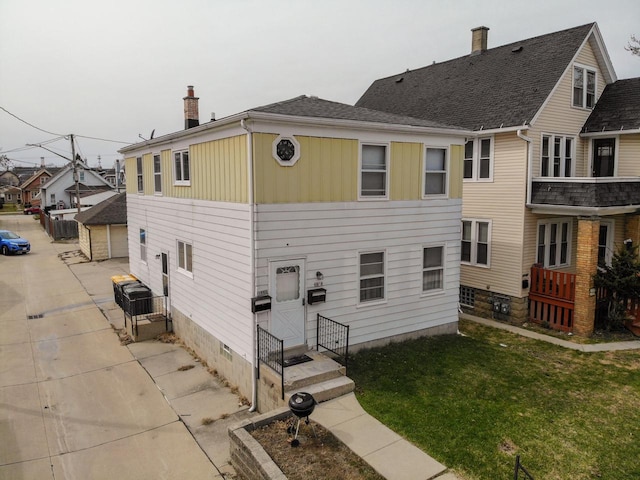 back of house with a lawn, crawl space, and a chimney