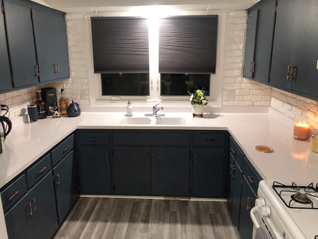 kitchen with light countertops, dark wood finished floors, tasteful backsplash, and a sink