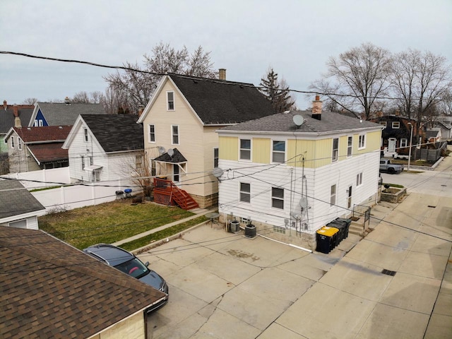 back of house with a chimney, fence, a patio area, and central AC