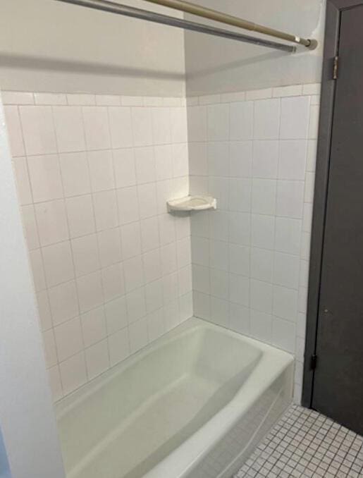 bathroom featuring tile patterned flooring and  shower combination