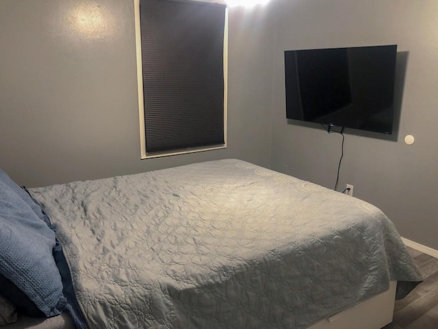 bedroom featuring wood finished floors and baseboards