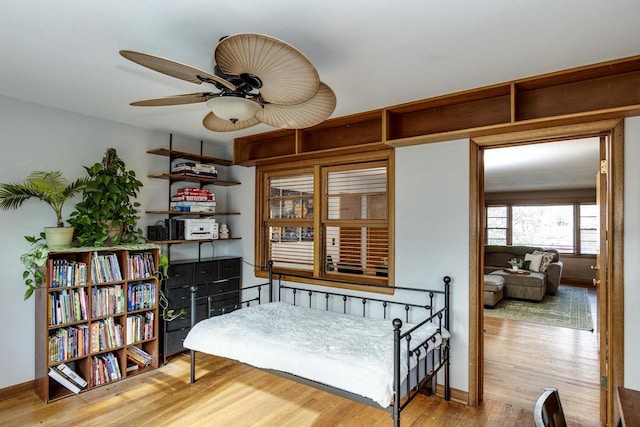 sitting room with wood finished floors, a ceiling fan, and baseboards