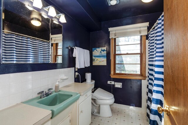 bathroom featuring tile patterned floors, toilet, vanity, and a shower with shower curtain