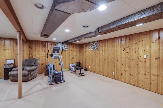 exercise room featuring wooden walls, recessed lighting, and visible vents