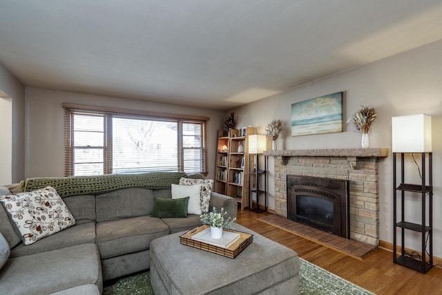 living area featuring wood finished floors and a stone fireplace