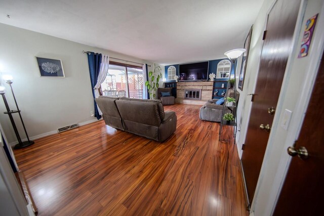 2607 King James Way, Fitchburg, WI 53719 - living area featuring a fireplace, wood finished floors, visible vents, and baseboards