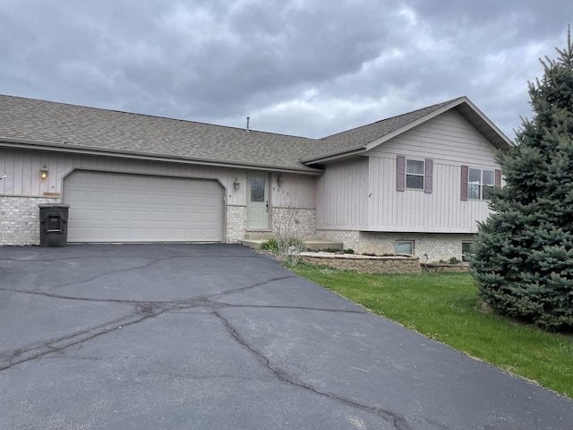 view of front of home with brick siding, roof with shingles, a garage, and aphalt driveway