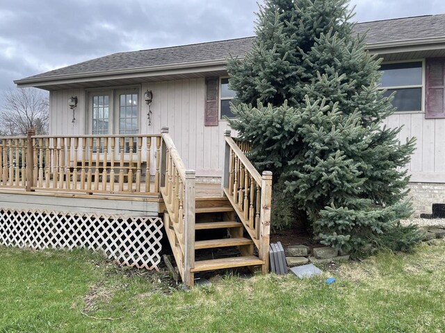 rear view of house featuring roof with shingles and a deck
