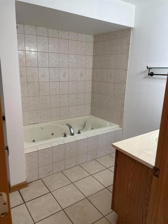 bathroom with tile patterned floors, vanity, and a tub with jets