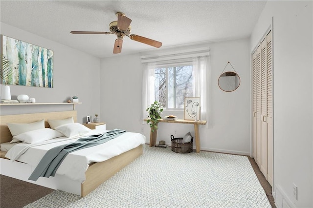 carpeted bedroom with a ceiling fan, a textured ceiling, and a closet