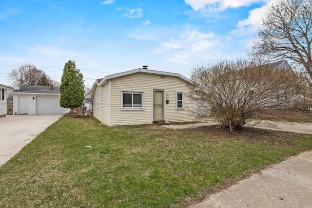 bungalow with a front lawn, an outbuilding, and a detached garage
