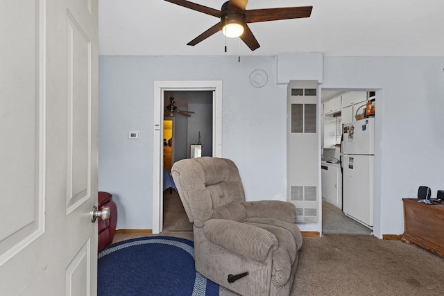 sitting room with carpet floors, a ceiling fan, a heating unit, and baseboards