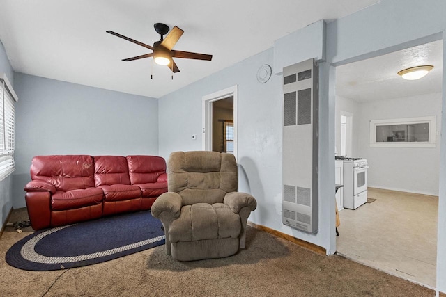 carpeted living room with a healthy amount of sunlight, a ceiling fan, and a heating unit