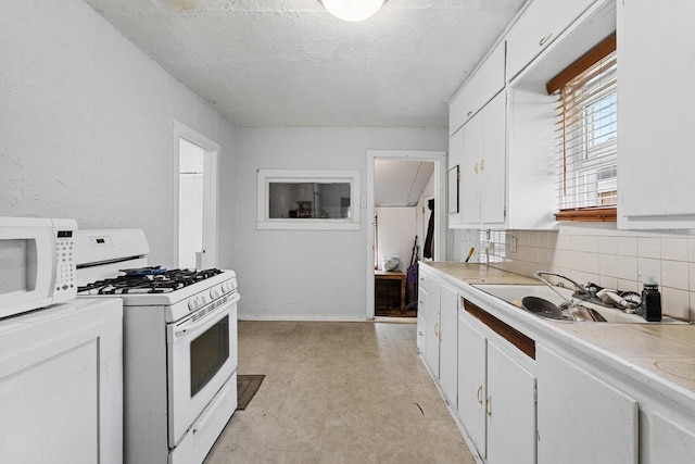 kitchen with light floors, light countertops, backsplash, a sink, and white appliances