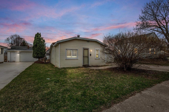 bungalow-style home featuring an outdoor structure, a detached garage, and a lawn