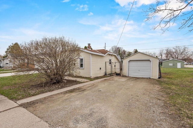 exterior space featuring a garage, driveway, and an outdoor structure