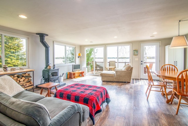 living room with recessed lighting, wood finished floors, and a wood stove