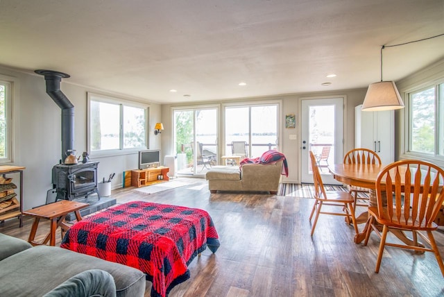 living room featuring recessed lighting, wood finished floors, and a wood stove