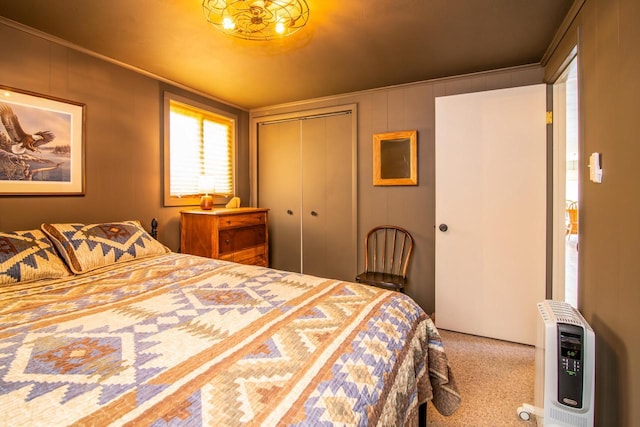 bedroom with heating unit, ornamental molding, carpet, and a closet