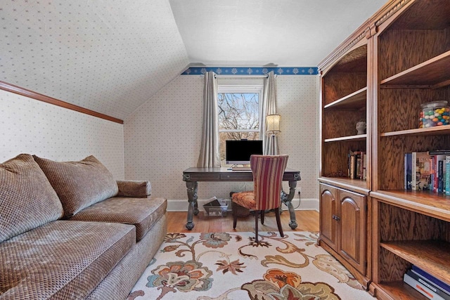 office area with light wood-type flooring, wallpapered walls, baseboards, and lofted ceiling
