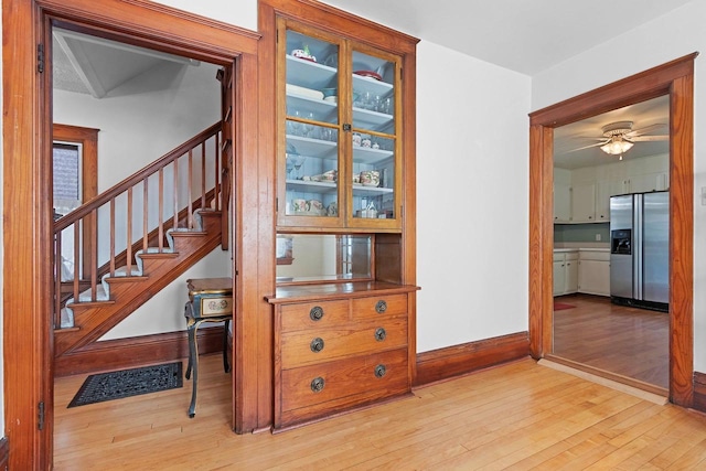 interior space featuring baseboards, a ceiling fan, visible vents, and wood-type flooring