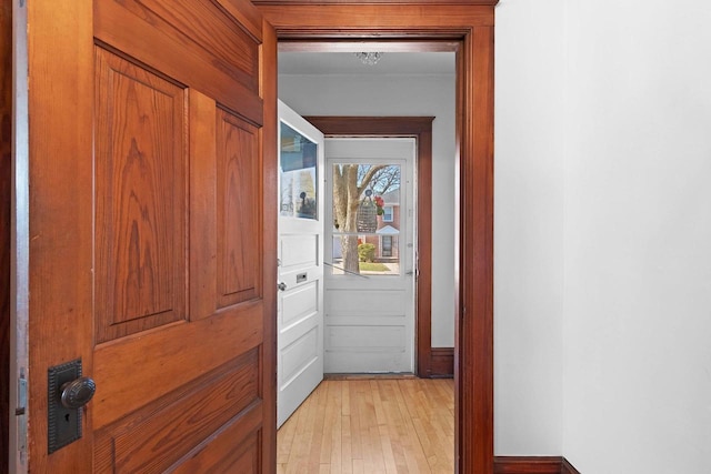 hall featuring light wood finished floors and baseboards