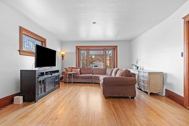 living area with baseboards and light wood-type flooring