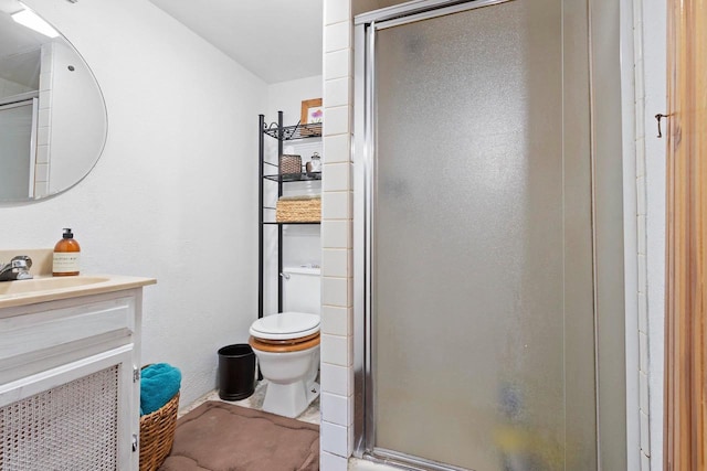 bathroom featuring a shower stall, toilet, and vanity