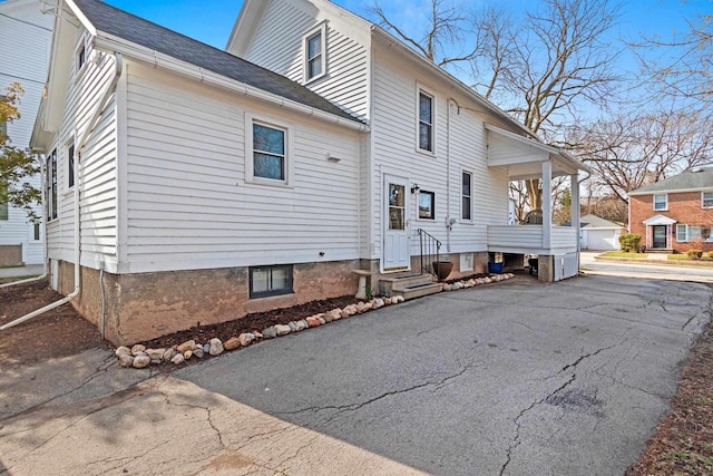rear view of property with a garage and entry steps
