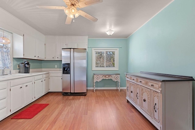 kitchen featuring a sink, ceiling fan, light wood finished floors, white cabinets, and stainless steel refrigerator with ice dispenser