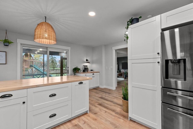 1620 E Murdock Ave, Oshkosh, WI 54901 - kitchen featuring white cabinets, recessed lighting, light wood finished floors, butcher block countertops, and stainless steel fridge