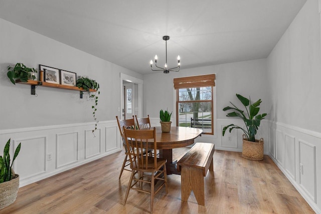 1620 E Murdock Ave, Oshkosh, WI 54901 - dining area featuring a chandelier, light wood-style floors, a decorative wall, and wainscoting