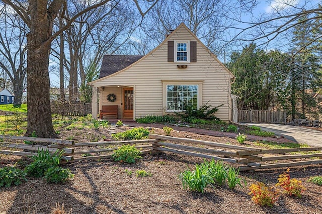 view of front of home featuring roof with shingles and fence private yard