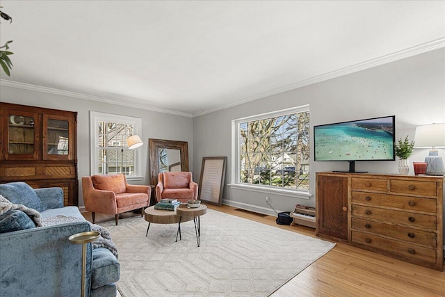 living room with light wood finished floors, visible vents, and ornamental molding