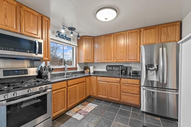 12759 N Shoreland Pkwy, Mequon, WI 53092 - kitchen featuring appliances with stainless steel finishes, a sink, dark tile patterned flooring, and dark stone counters