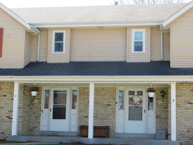 N17W5247 Garfield Cir Unit N17W5249, Cedarburg, WI 53012 - view of front of house featuring roof with shingles, a porch, and brick siding