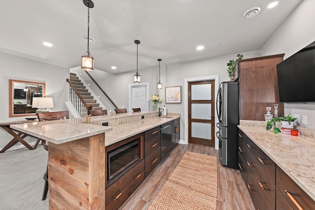 N56W27213 Crispin Ct, Lisbon, WI 53089 - kitchen with stainless steel appliances, a peninsula, visible vents, pendant lighting, and a breakfast bar area