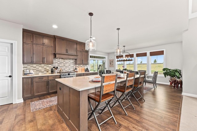 N56W27213 Crispin Ct, Lisbon, WI 53089 - kitchen with light countertops, a healthy amount of sunlight, dark wood-type flooring, and a kitchen breakfast bar