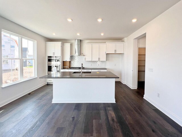 4003 Banbury St, Windsor, WI 53598 - kitchen featuring wall chimney exhaust hood, stainless steel double oven, a center island with sink, white cabinets, and recessed lighting