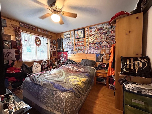 319 Hilltop Ct, Warrens, Warrens, WI 54666 - bedroom with wood finished floors, wood walls, and ceiling fan