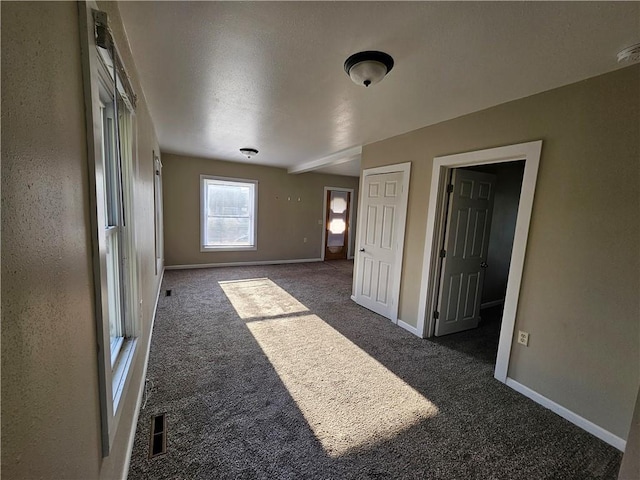 unfurnished room with baseboards, carpet, and visible vents